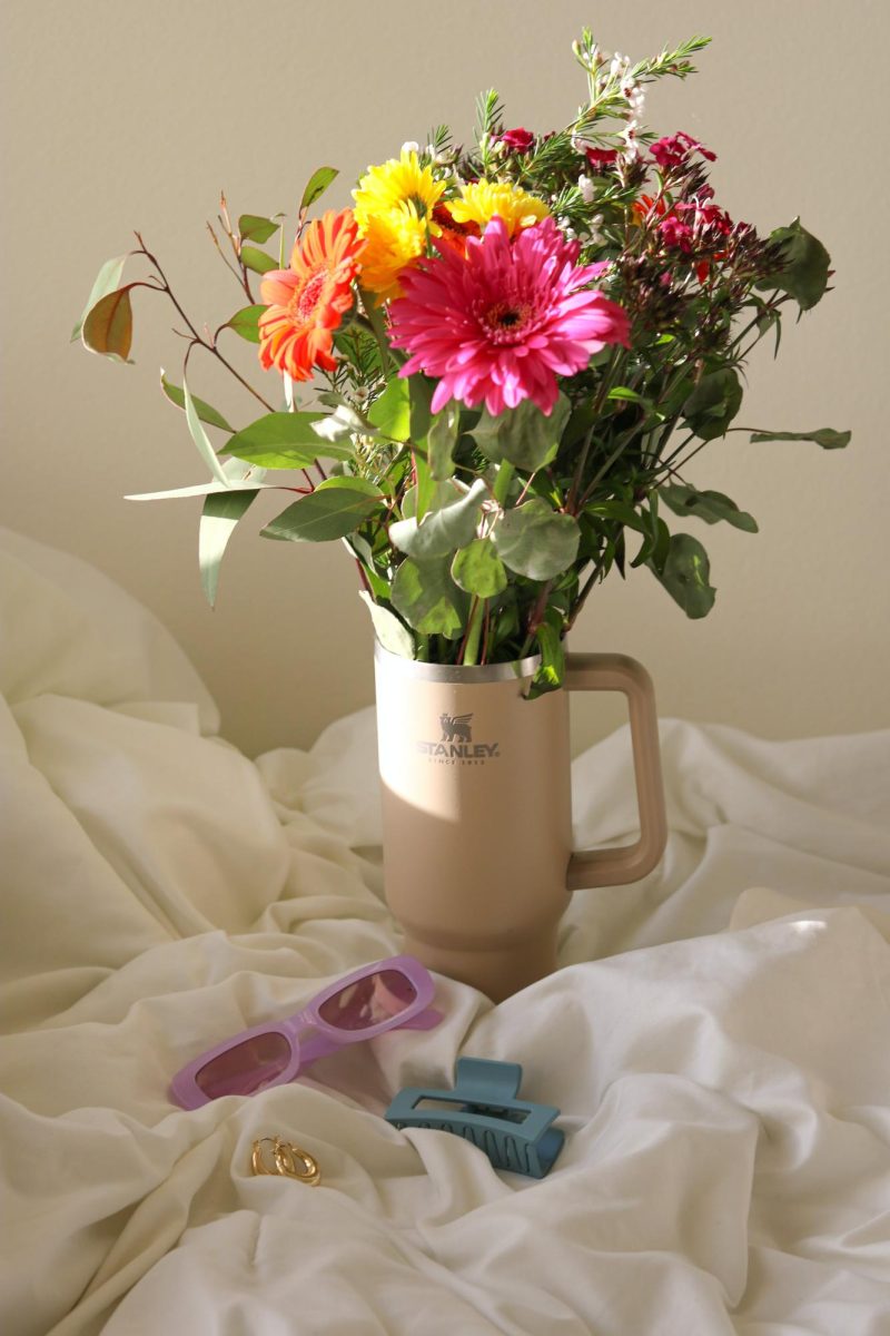 Stanley tumblers are the latest trend in hydration. https://www.pexels.com/photo/a-vase-with-flowers-on-a-bed-with-a-pair-of-sunglasses-16488147/
